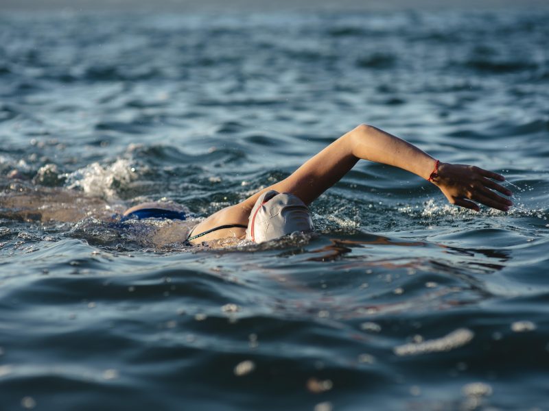 female-swimmer-with-cap-goggles-swimming-water
